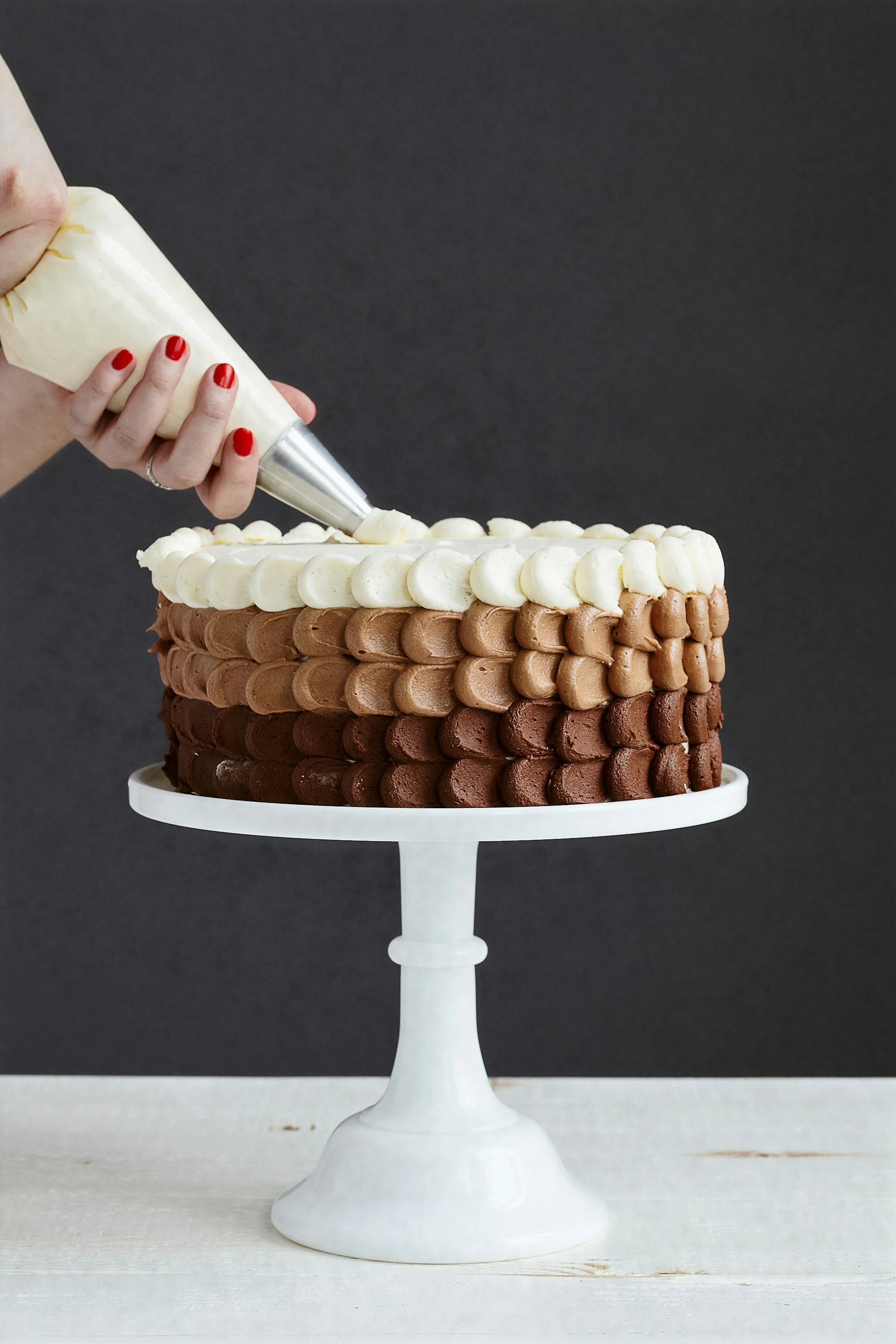 Baker piping an ombre celebration cake