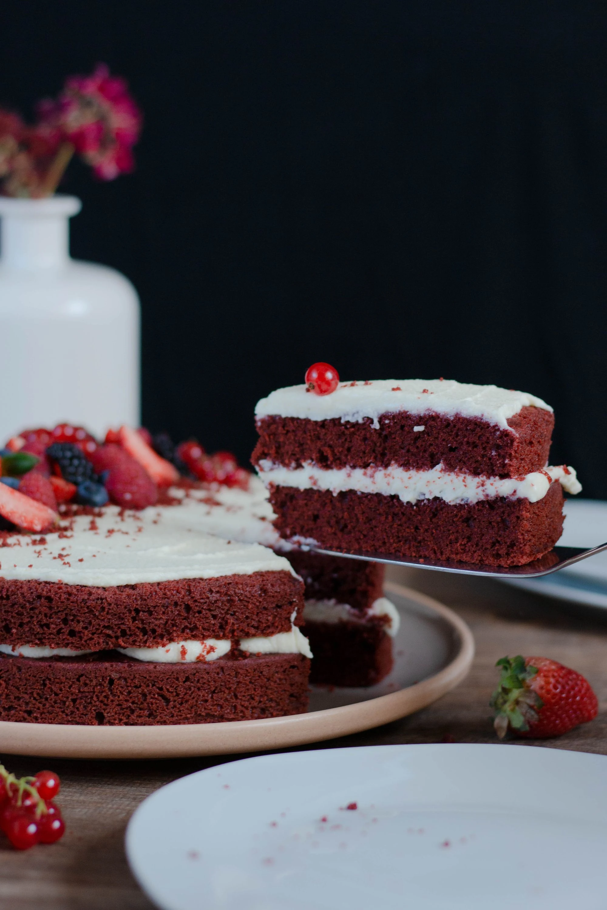 Red velvet layer cake with a slice lifted